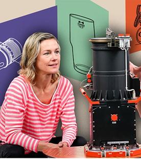 Ein bunte Collage mit Graphiken und den Schauspielern Rhea Harder-Vennewald und Hendrik Duryn, die eine DDR-Erfindung bestaunen. 