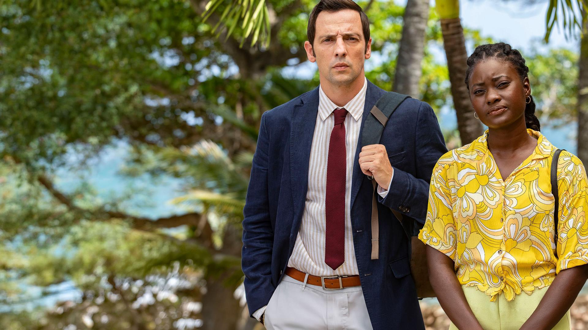 "Death in Paradise - Feuer im Herzen": Detective Neville Parker (Ralf Little) und Naomi Thomas (Shantol Jackson) stehen Seite an Seite und starren geradeaus.