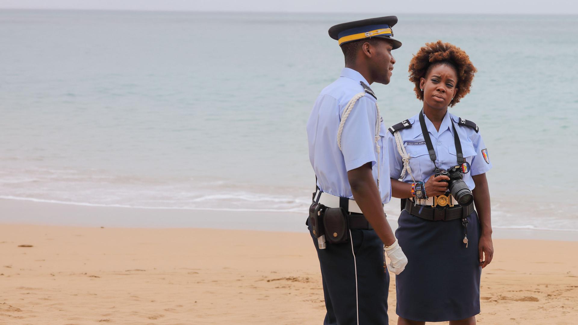 "Death in Paradise - Hot Spots": JP Hooper (Tobi Bakare), Ruby Patterson (Shyko Amos) und DI Jack Mooney (Ardal O''Hanlon) stehen sich am Strand gegenüber und unterhalten sich.