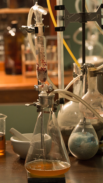 "Deep Time History: Der Weg in die Moderne": Glaskolben mit Flüssigkeit stehen auf einem Tisch.