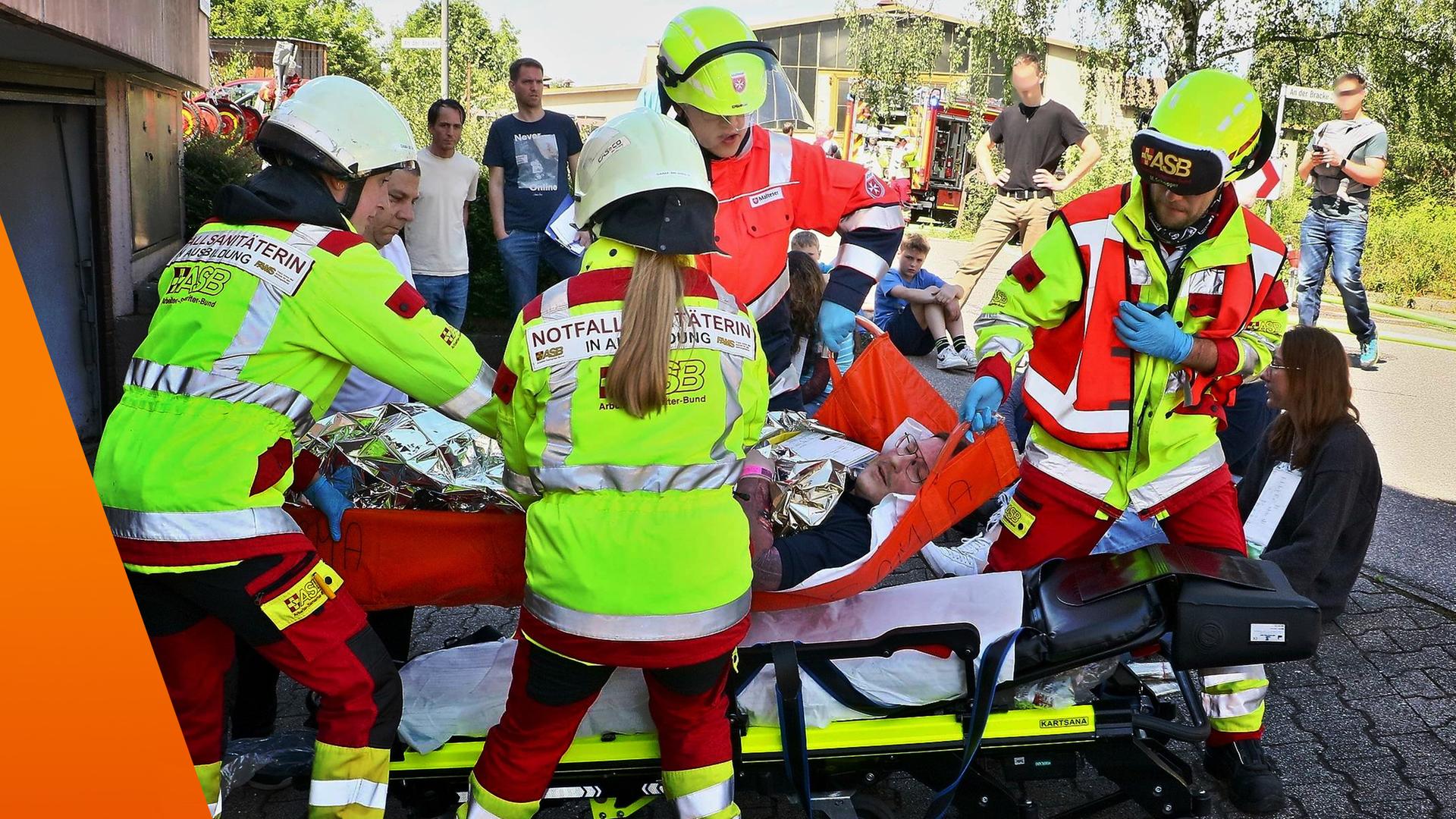 Rettungskräfte kümmern sich um einen Mann, der auf einer Liege liegt