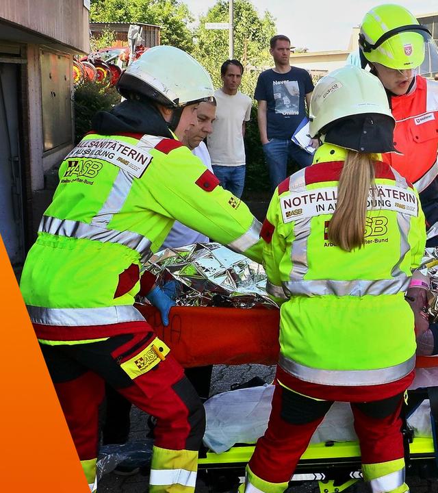 Rettungskräfte kümmern sich um einen Mann, der auf einer Liege liegt