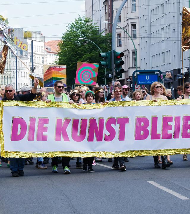 Demonstranten tragen ein Banner vor sich her, auf dem Die Kunst bleibt frei steht.