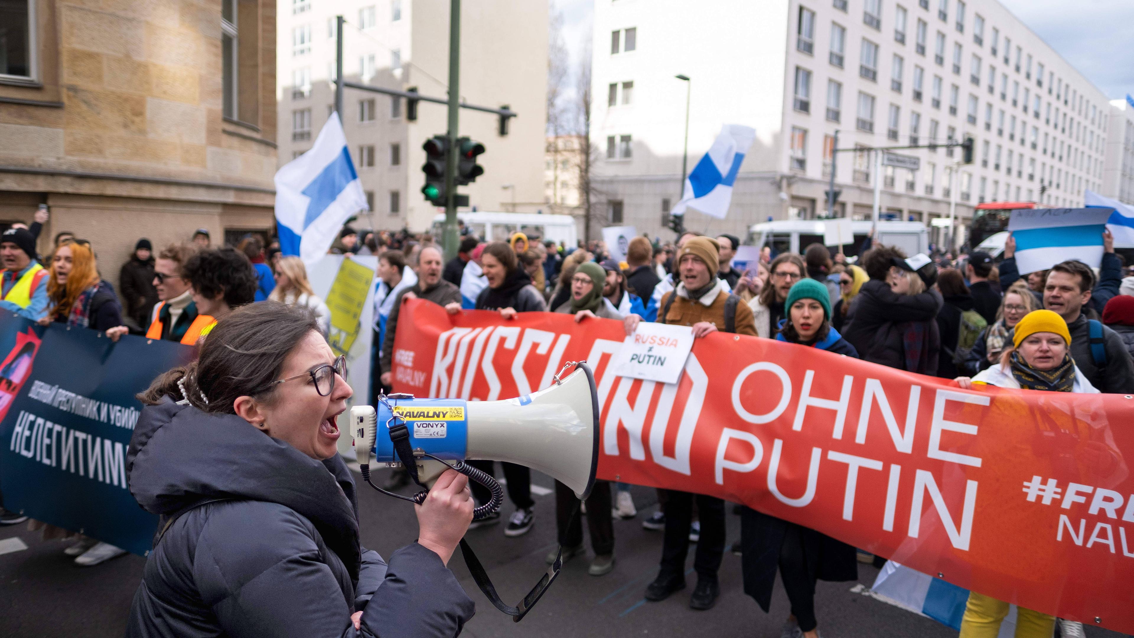 Ein Demonstrationszug mit Bannern mit russischer Schrift. Auf einem roten Banner steht Russland ohne Putin.