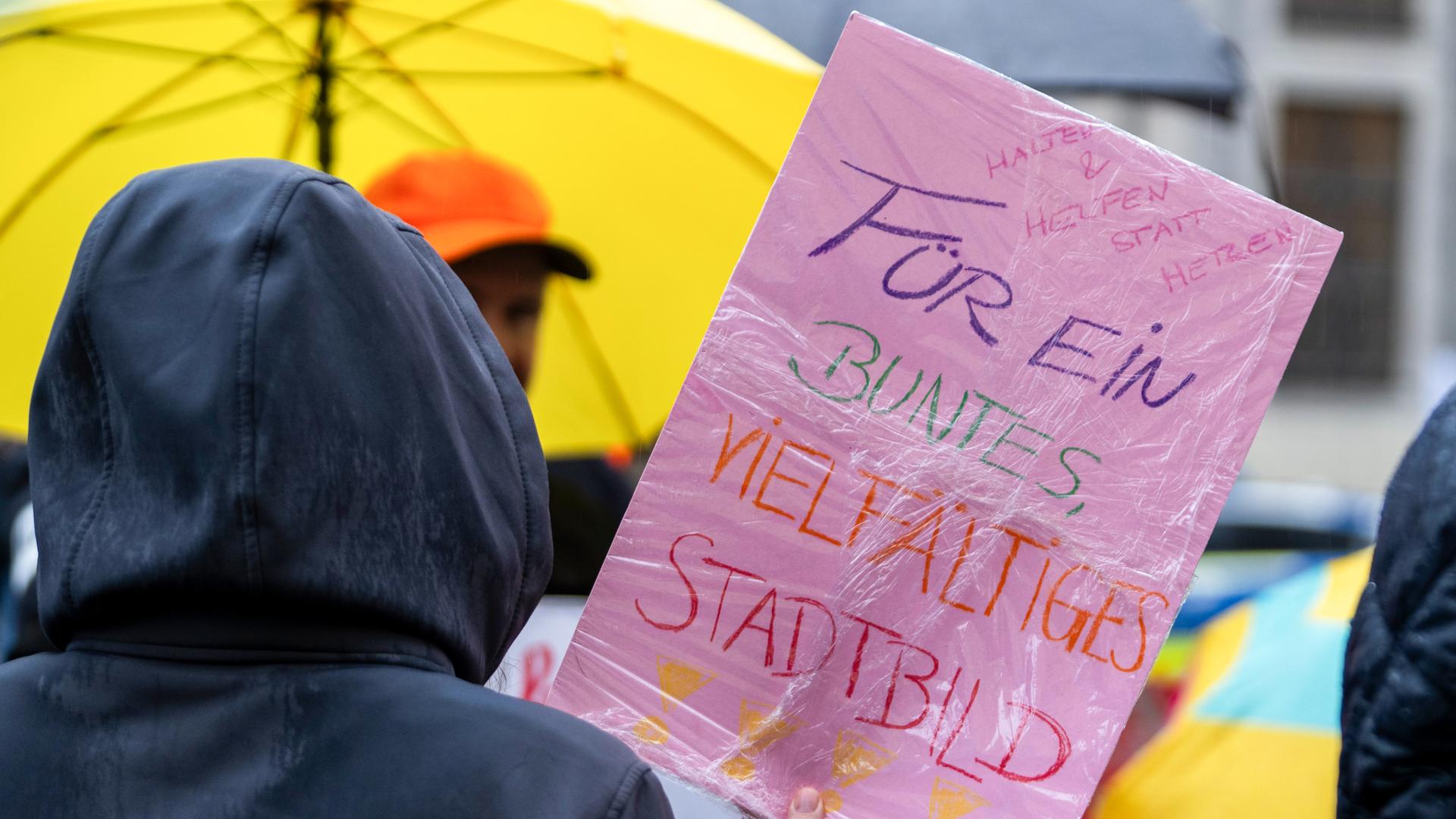 Im strömenden Regen demonstrieren Menschen auf dem Odeonsplatz. Unter anderem rief der Bayerische Flüchtlingsrat zu dieser Demonstration gegen die Stadtbild-Aussage des Bundeskanzlers auf. 