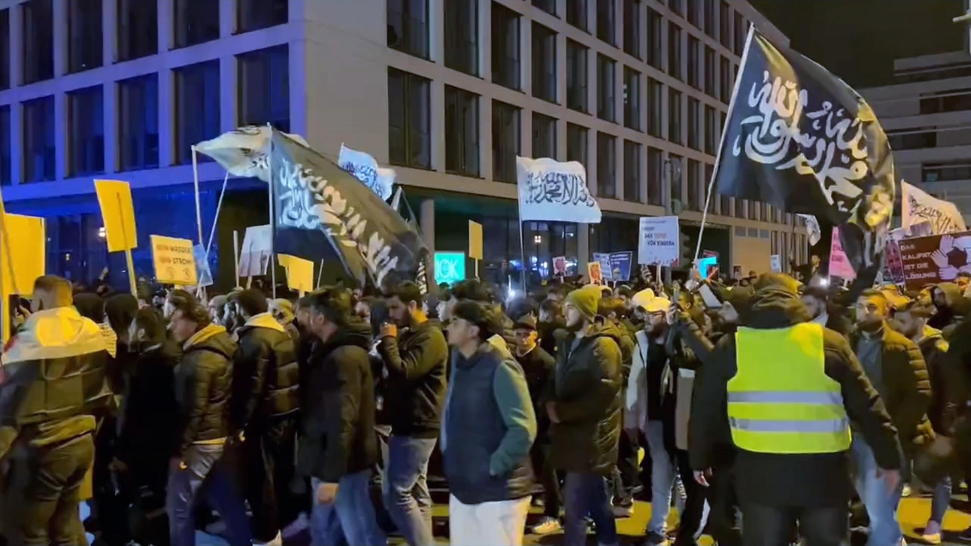 Schwarz-weiße Flaggen mit Glaubenbekenntnissen auf Demo in Essen
