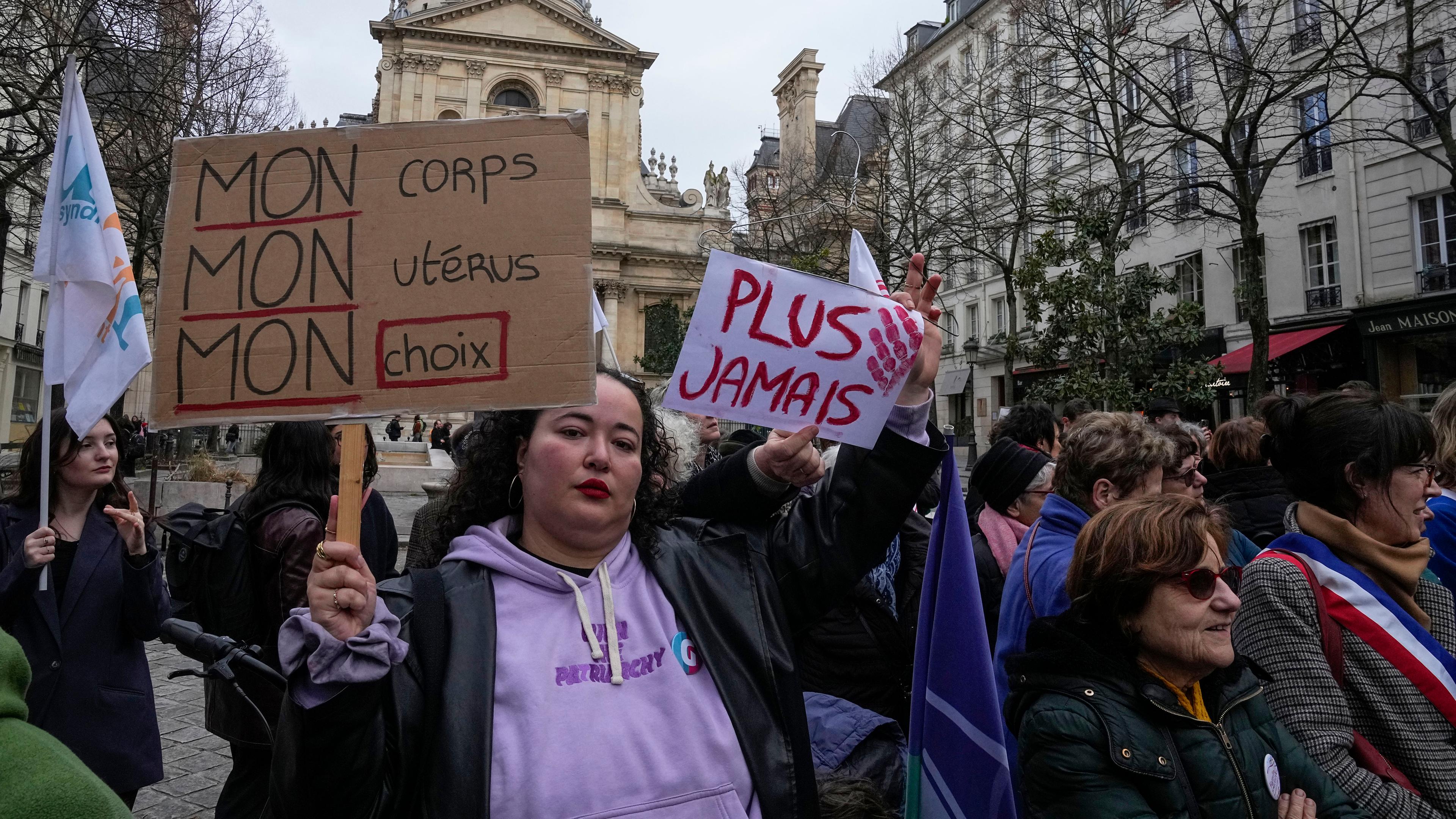Frankreich, Paris: Eine Abtreibungsbefürworterin hält Schilder mit der Aufschrift "Mein Körper, meine Gebärmutter, meine Entscheidung" und "Nie wieder" während einer Demonstration für Abtreibungsrechte vor der Universität La Sorbonne.