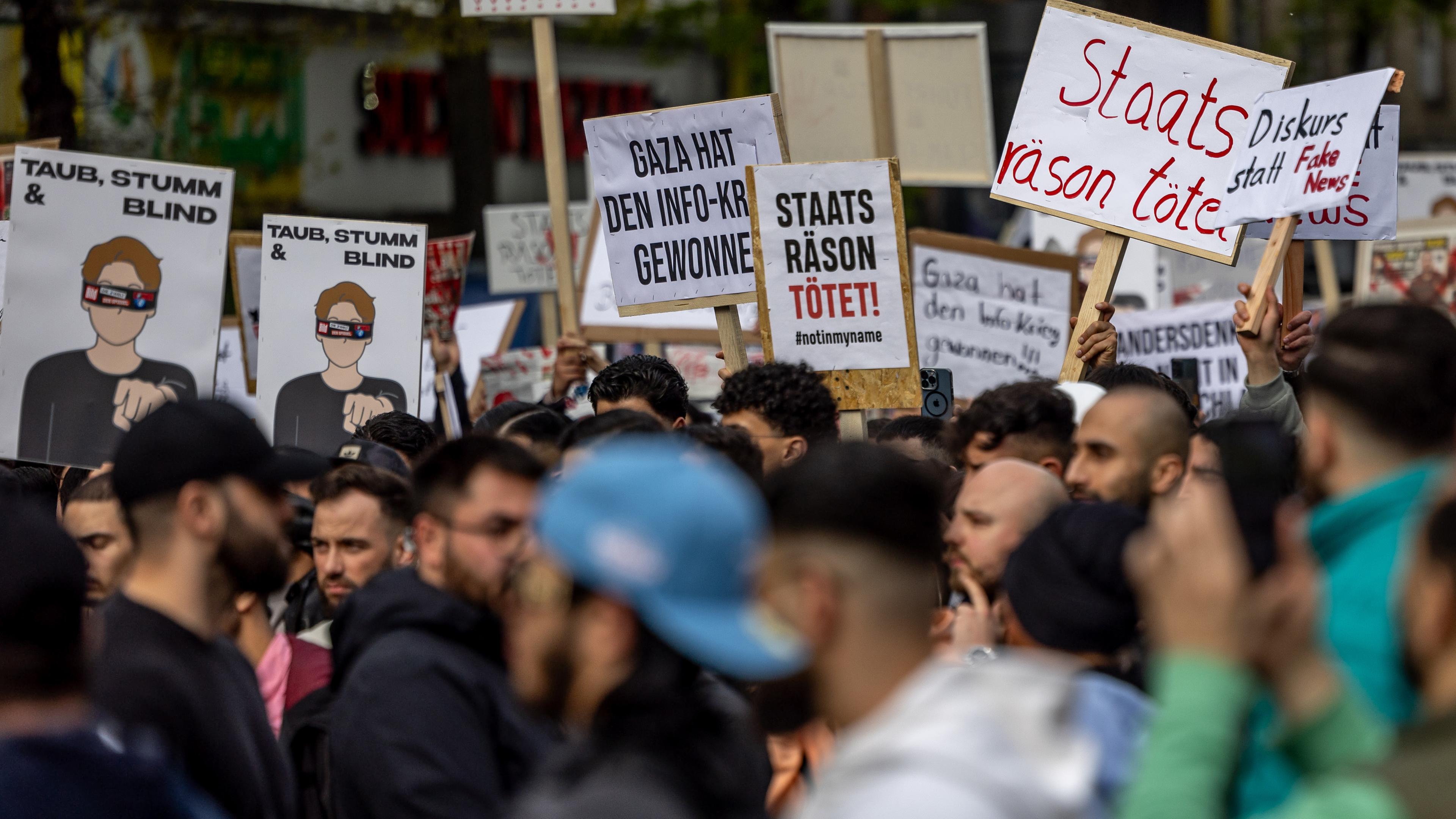 Teilnehmer einer Islamisten-Demo halten Plakate mit der Aufschrift "Staatsräson tötet" in die Höhe am 27.04.2024 in Hamburg.