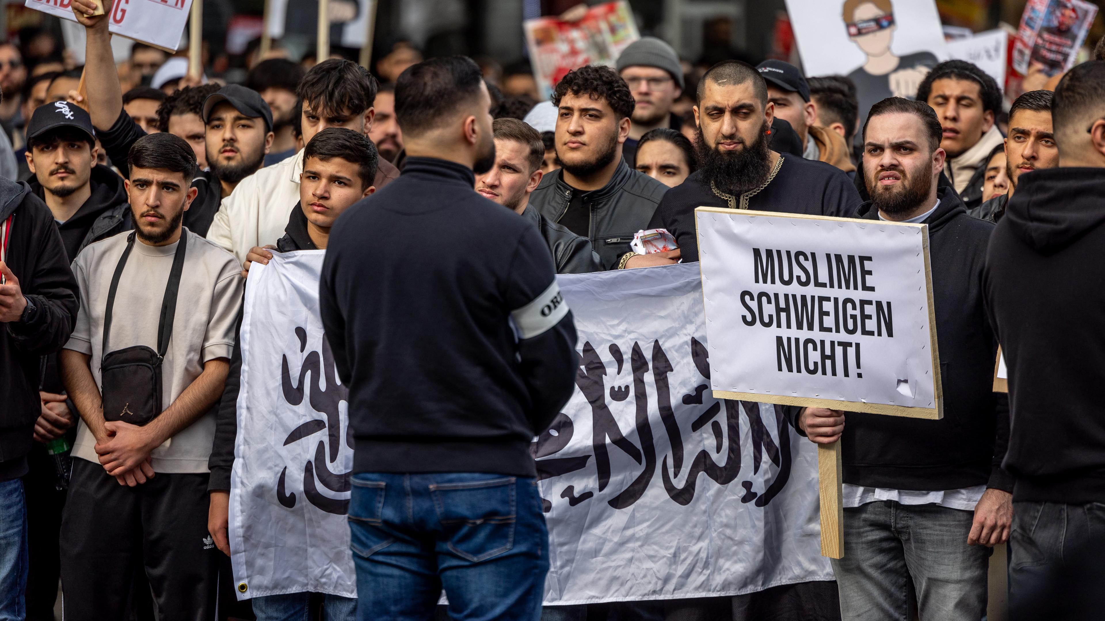 Hamburg: Teilnehmer einer Islamisten-Demo halten ein Plakat mit der Aufschrift "Muslime schweigen nicht" in die Höhe.