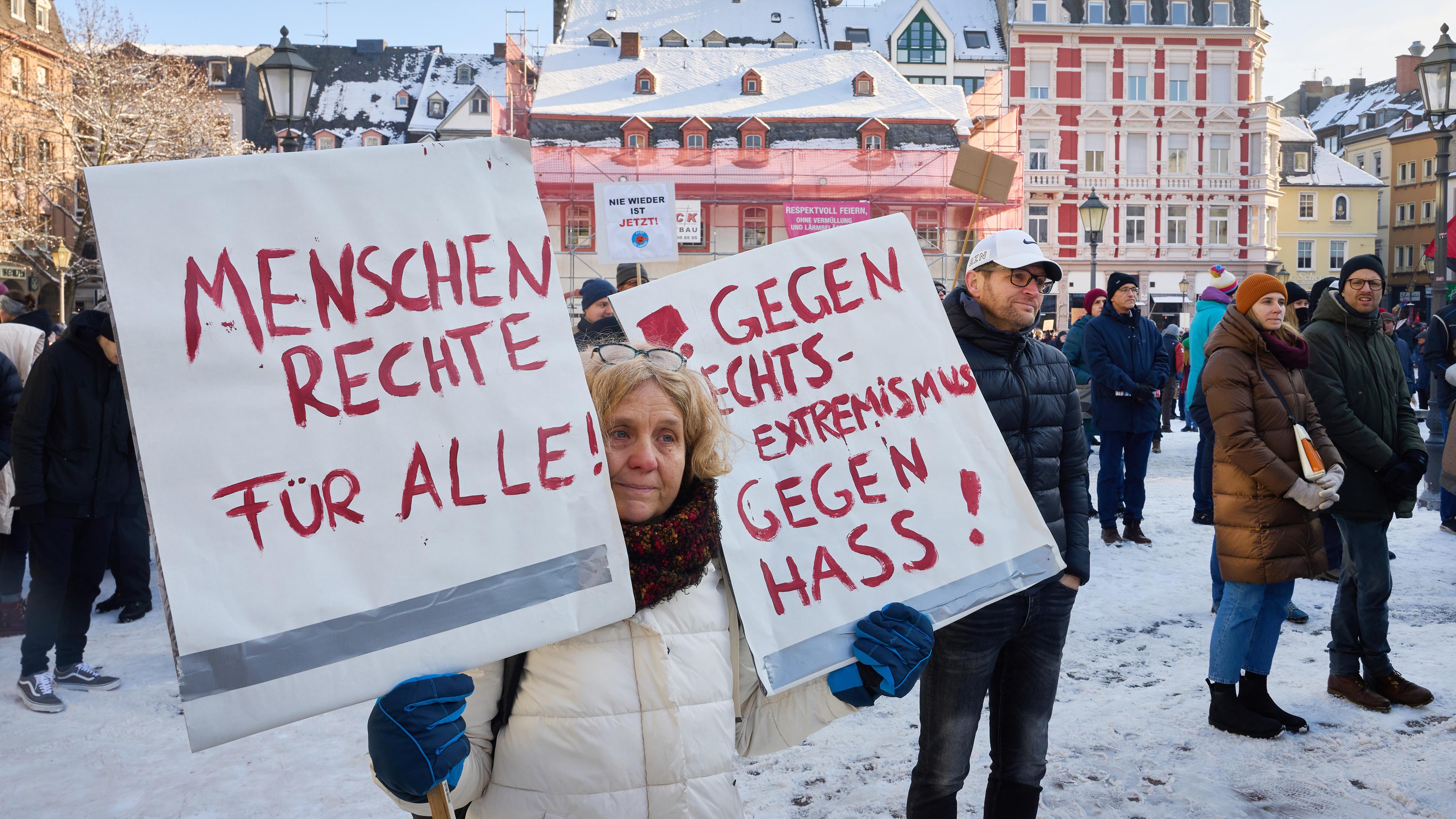  "Menschenrechte für Alle" und "gegen Rechtsextremismus, gegen Hass!" ist auf den beiden Schildern zu lesen, die eine Frau bei einer Demonstration in Koblenz gegen Rechts hält.