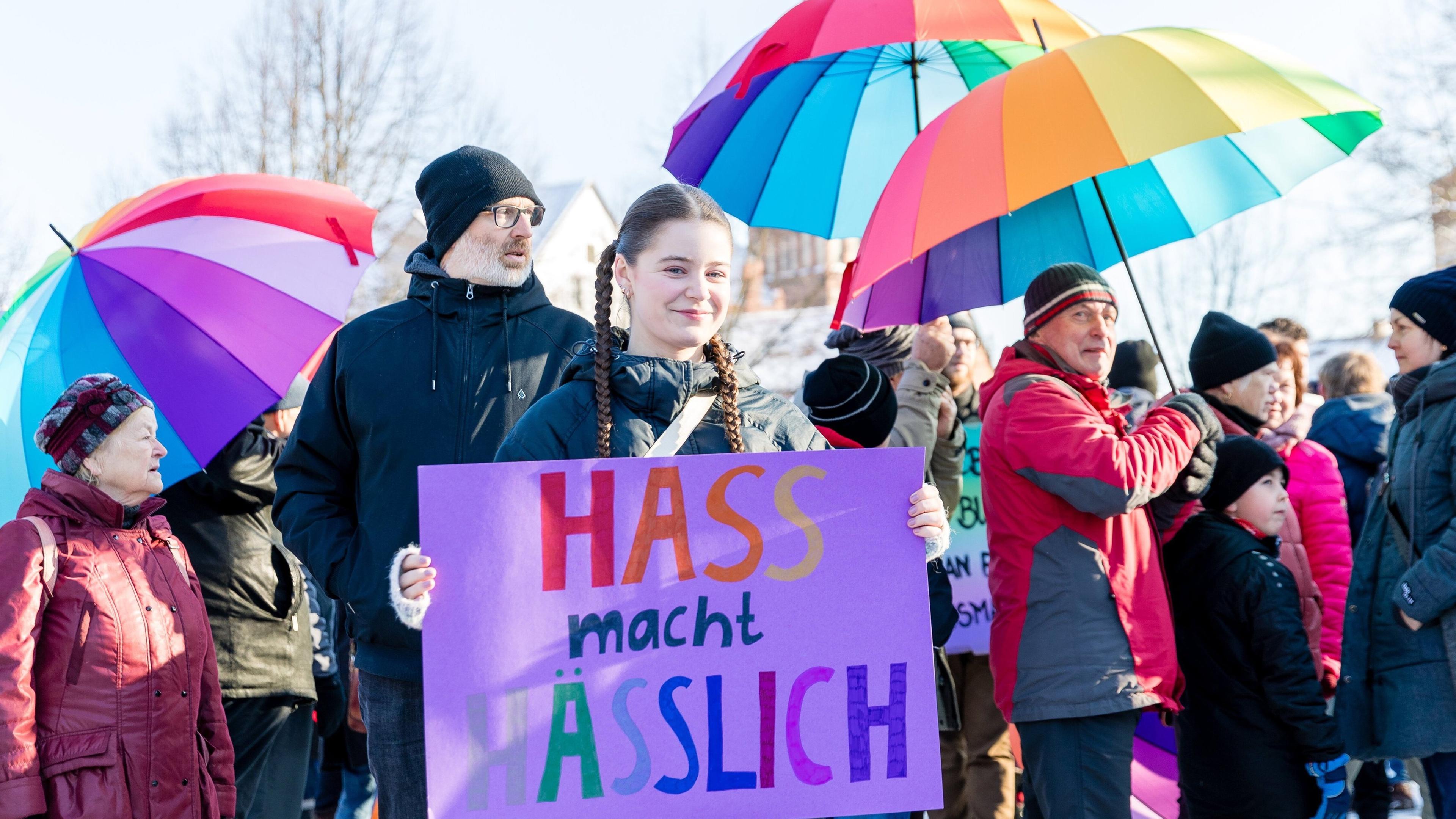 Menschen halten Schirme in Regenbogenfarben bei der Demonstration "Bunte Zukunft statt braunes Hinterland" am 20.01.2024 in Spremberg.