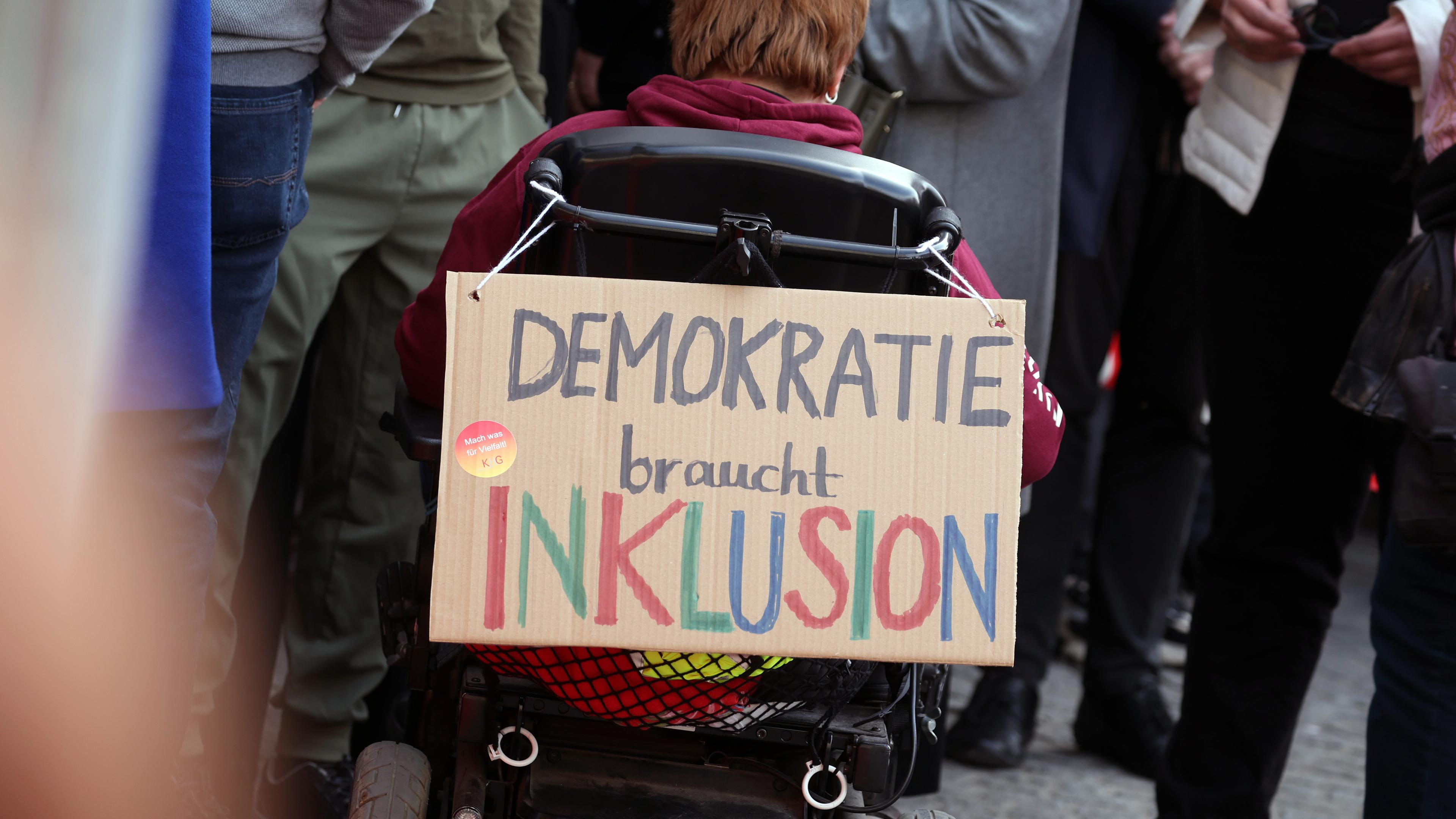 "DEMOKRATIE braucht INKLUSION" ist auf einem an einem Rollstuhl befestigten Plakat bei einer Demonstration gegen rechts in der Innenstadt zu lesen am 03.03.2024 in Würzburg.