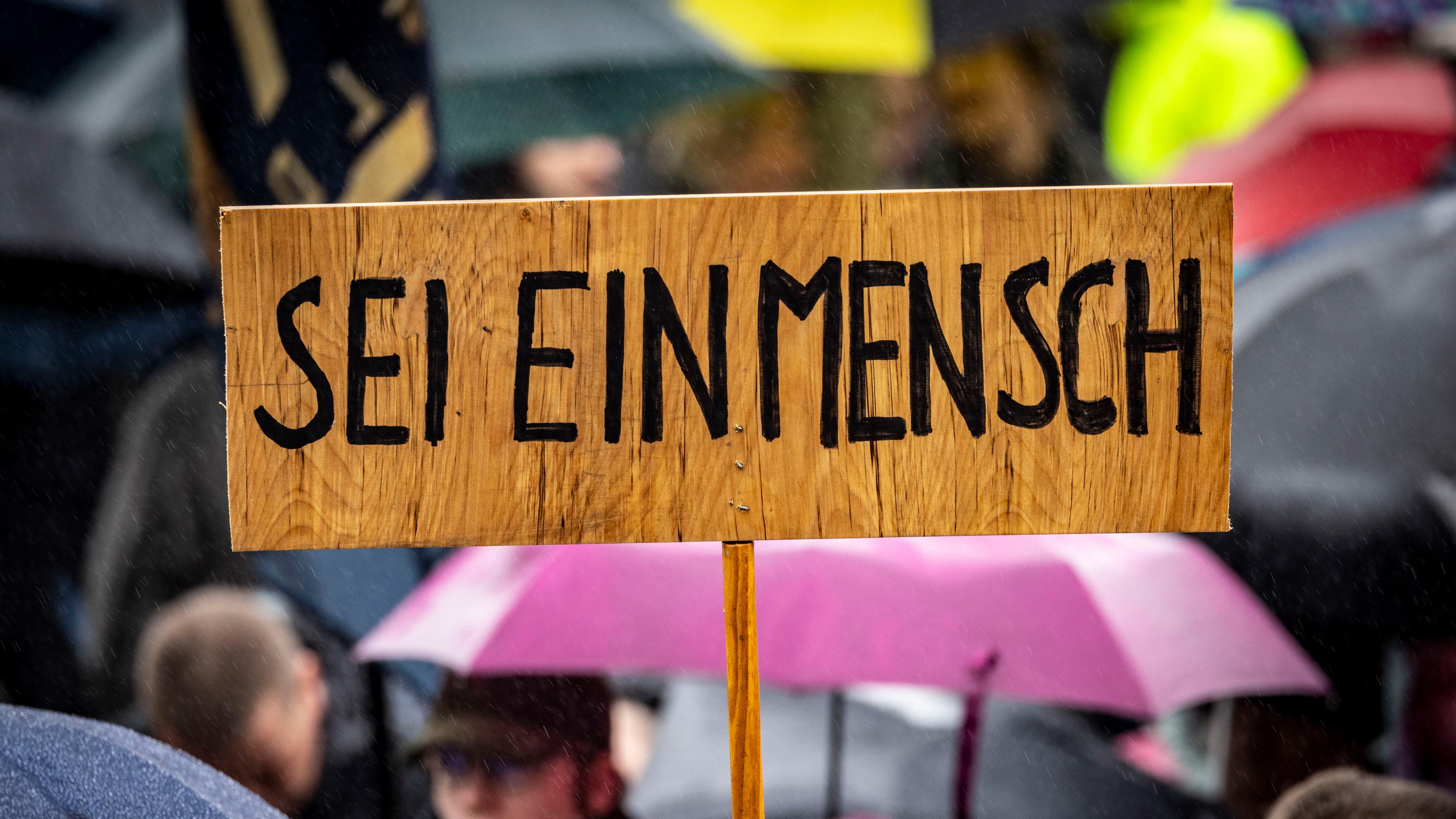  "Sei ein Mensch" steht auf einem Schild während einer Demonstration gegen Rechtsextremismus.