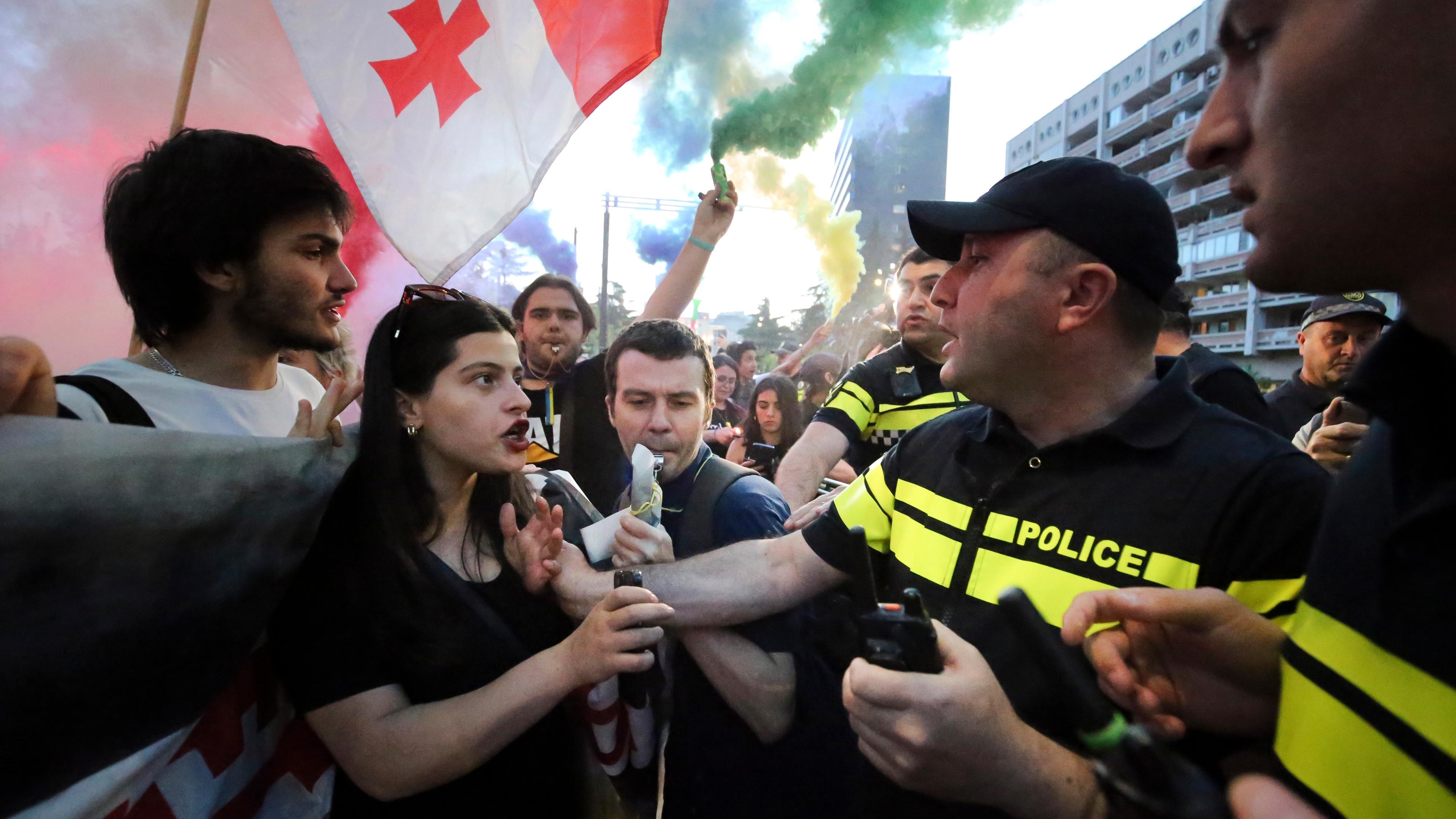 Georgien, Tbilisi: Die Polizei blockiert oppositionelle Demonstranten mit georgischen Nationalflaggen, die sich zu einer Kundgebung gegen das "russische Gesetz" versammelt haben.