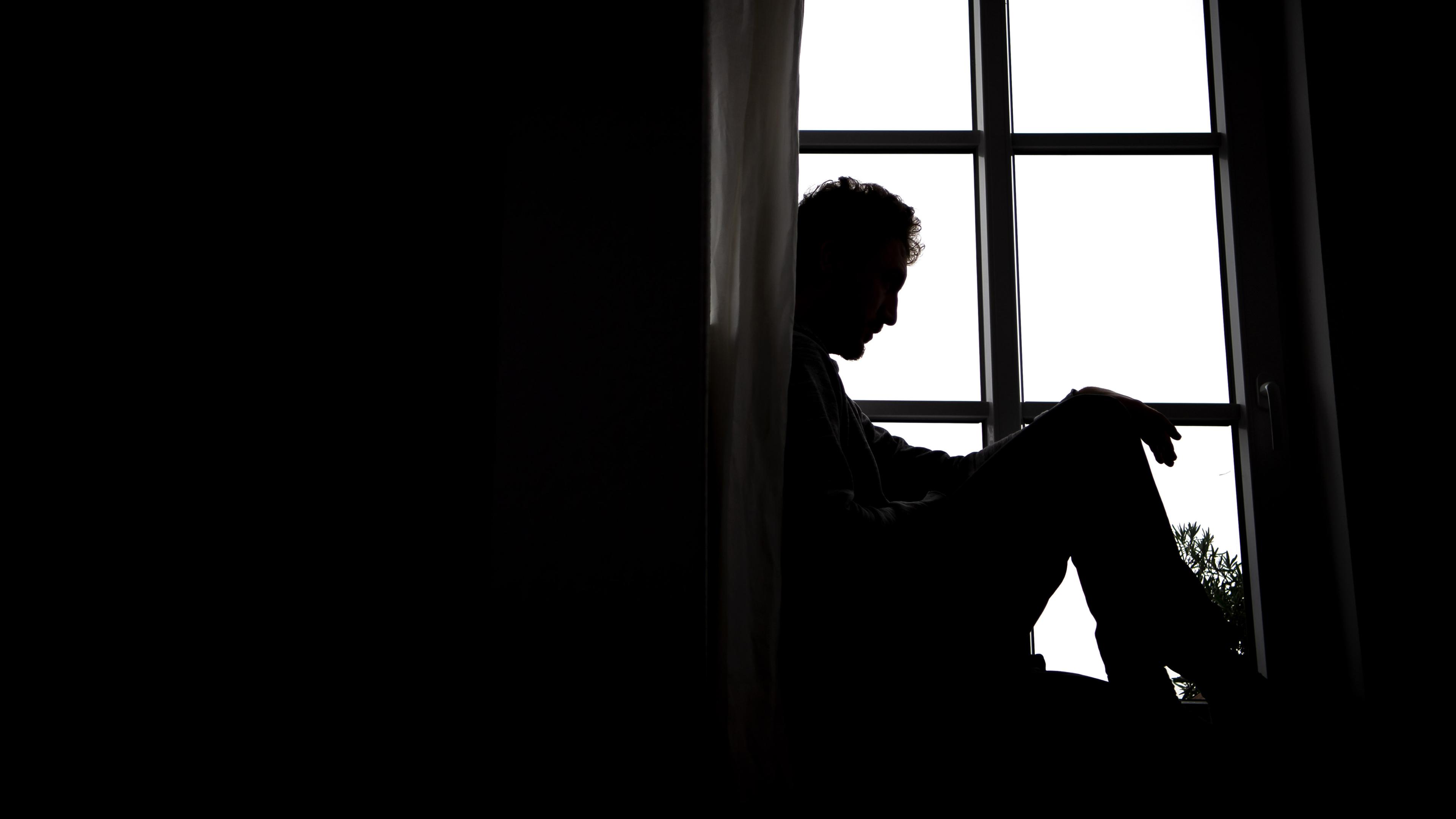 Symbolbild: Ein Einsamer Mann sitzt am Fenster