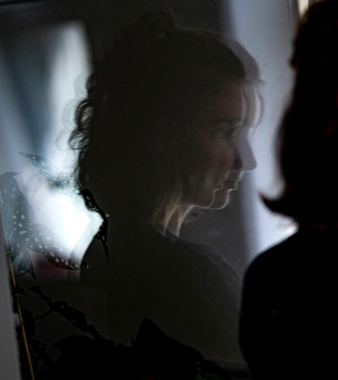Eine junge Frau steht in ihrer Wohnung an einem Fenster, aufgenommen am 13.07.2021 in Berlin