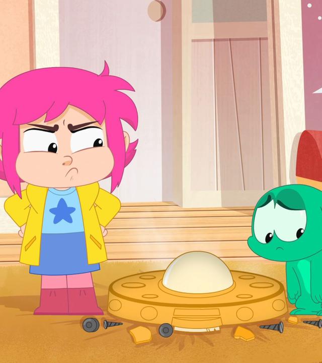 Rebecca (links) und Ernest (rechts) stehen ratlos vor dem neuen Staubsauger-Roboter (Mitte).