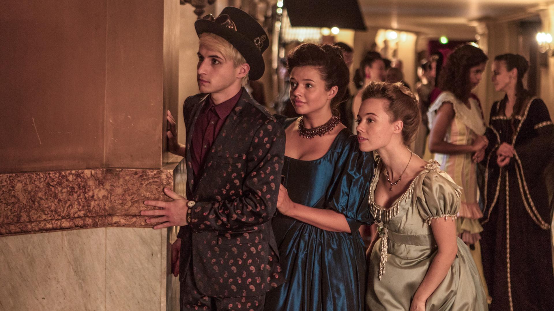 Frank, Kennedy und Bree beobachten beim Ball der Zeitreisenden heimlich Lenas Mutter und Franks Vater, die sich angeregt unterhalten.