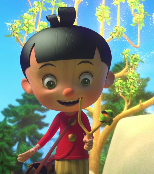 Pinocchio freut sich über einen Zweig, der sich perfekt für eine Steinschleuder eignet. Er hält den Zweig in der Hand und schaut ihn begeistert an. Hinter ihm sind ein großer Felsen und ein wunderschöner, glitzernder Baum zu sehen.