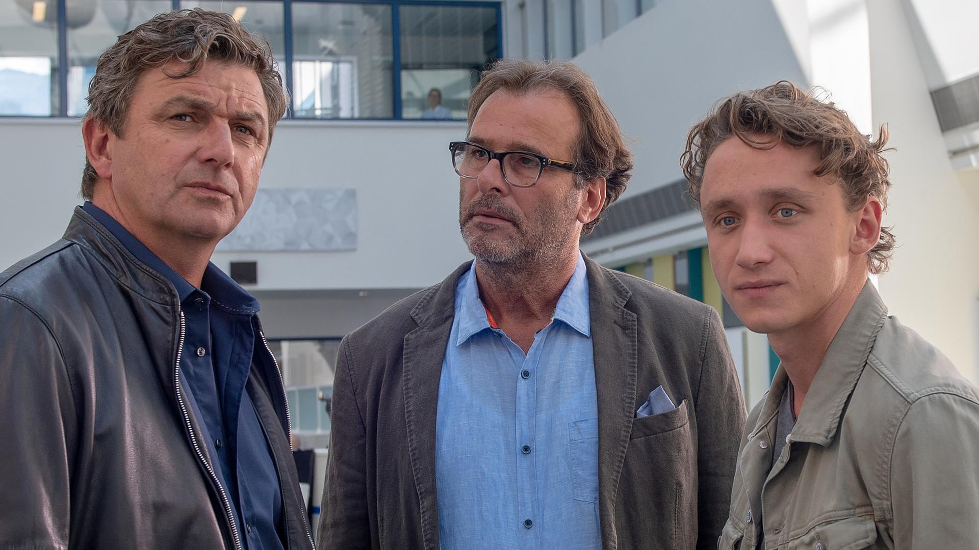Im Krankenhaus unterhält sich Dr. Martin Gruber (Hans Sigl) mit Robert Metzinger (Joachim Raaf) und Chris Weigand (Aaron Friesz).