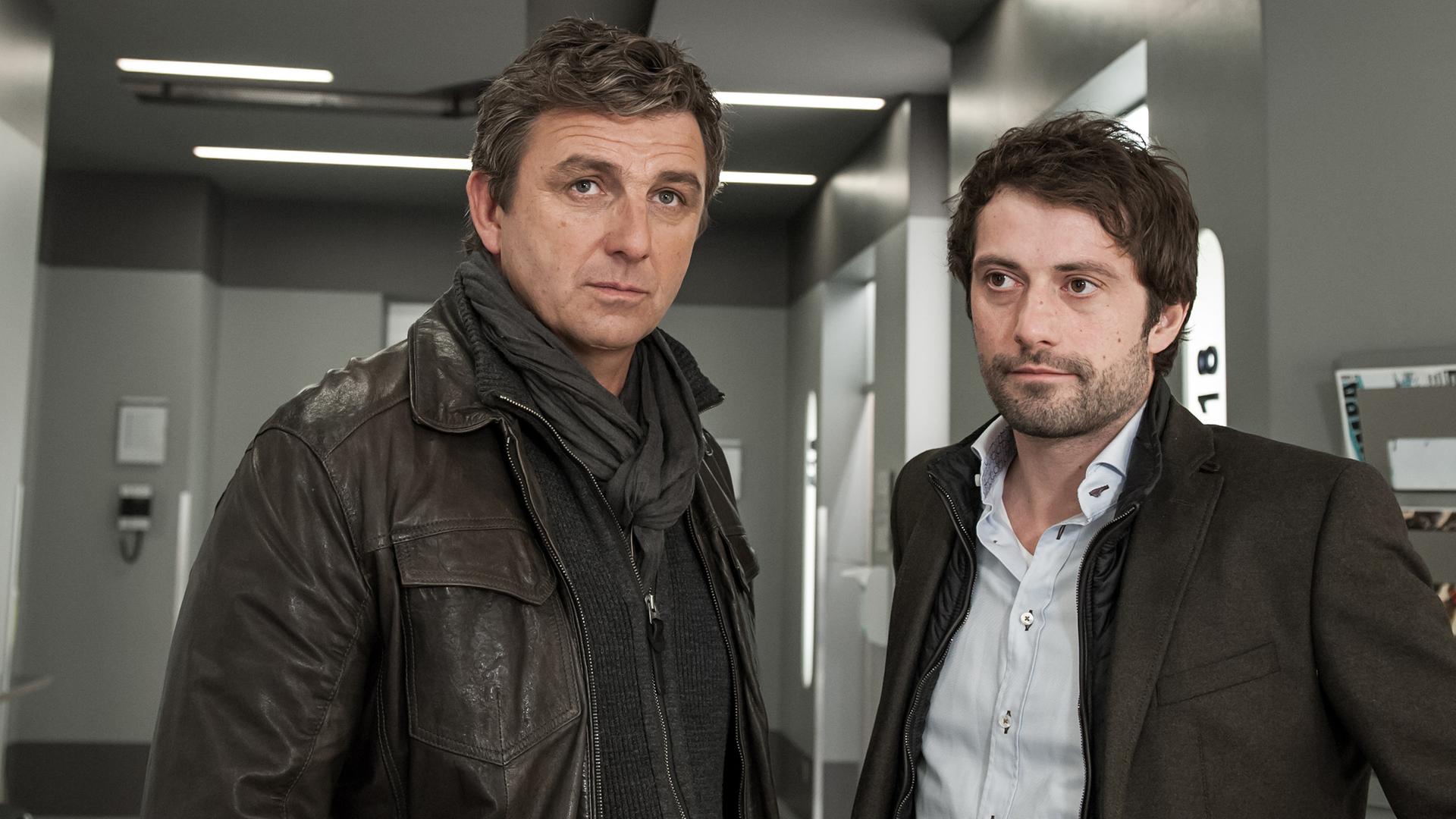 Martin Gruber (Hans Sigl) und Thomas Lambert (Björn von der Wellen) stehen nebeneinander im Flur des Krankenhauses