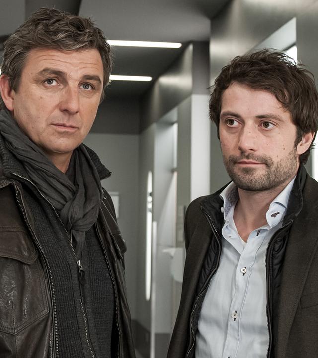 Martin Gruber (Hans Sigl) und Thomas Lambert (Björn von der Wellen) stehen nebeneinander im Flur des Krankenhauses