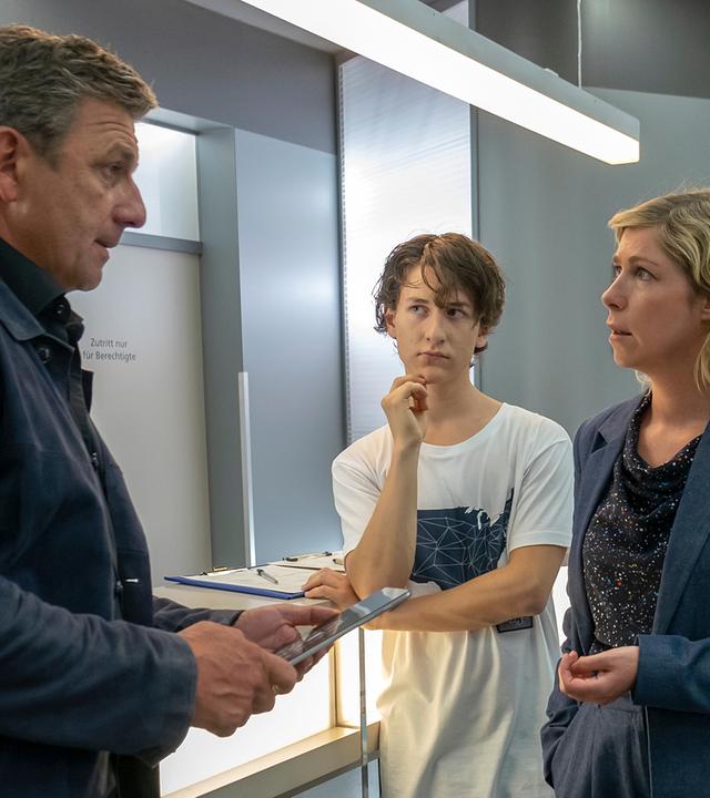 Im Krankenhausflur steht Martin (Hans Gruber) Franz (Josef Heynert), Lisa (Brigitte Zeh) und Lennard (Juri Sam Winkler) gegenüber. Die Familie blickt ihn entsetzt an.