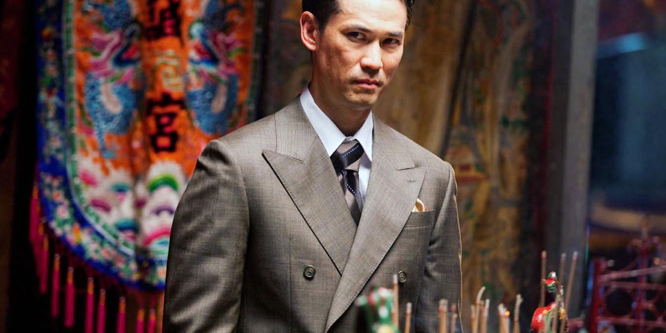 Asiate im Anzug mit skeptischen Blick