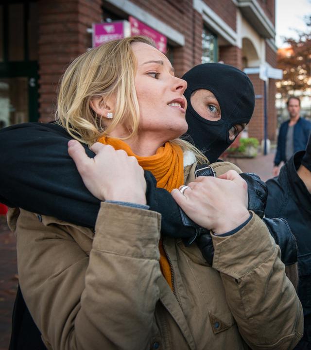 "Notruf Hafenkante - Der Clan": Ein maskierter Mann steht hinter Alina (Teresa Weißbach) und hält sie im Würgegriff. Sein maskierter Komplize steht neben den beiden und hält die Schiebetür eines dunklen Transporters auf. Mattes (Matthias Schloo) beobachtet die Szene aus der Ferne.