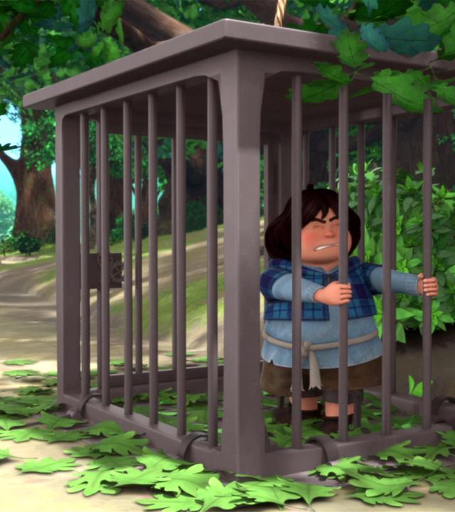 Tuck ist in einem großen, metallenen Käfig gefangen. Er rüttelt an den Stäben.