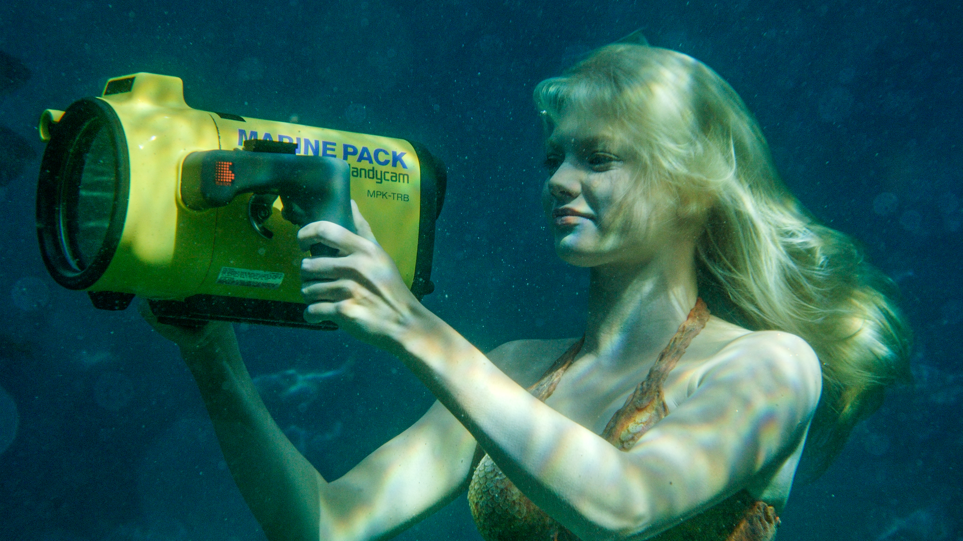 Rikki filmt unter Wasser mit einer gelben Unterwasserkamera.