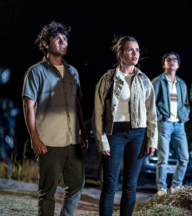 Dan (links), Issie (2.v.l.), Caleb (Mitte), Natasha (2.v.r.) und Caroline (rechts) stehen am Strand und blicken erstaunt in den Abendhimmel.