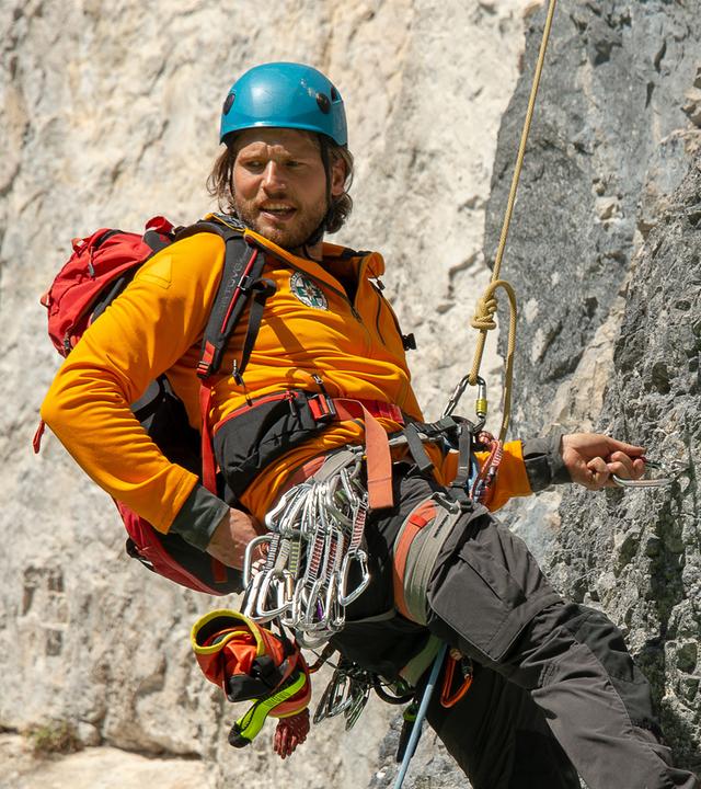 Bergretter Markus Kofler (Sebastian Ströbel) seilt sich an einer Felswand ab.