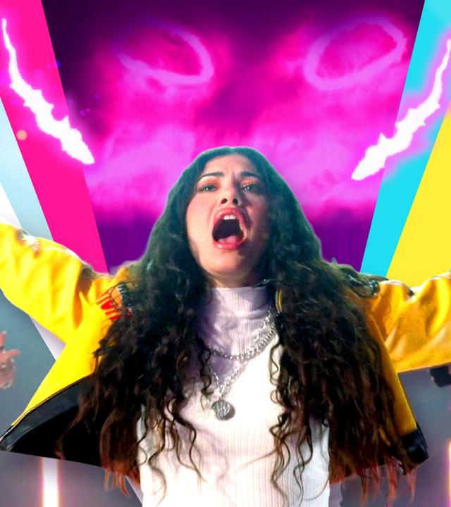 Jeannie hat die Arme ausgebreitet und im Hintergrund sind Tänzerinnen zu sehen. 