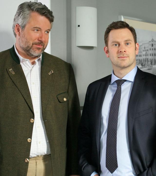 "Die Rosenheim-Cops - Der König kommt": Im Flur des Kommissariats stehen die Kollegen Stadler (Dieter Fischer), Sebastian König (Mark-Alexander Solf) und Sekretärin Stockl (Marisa Burger).