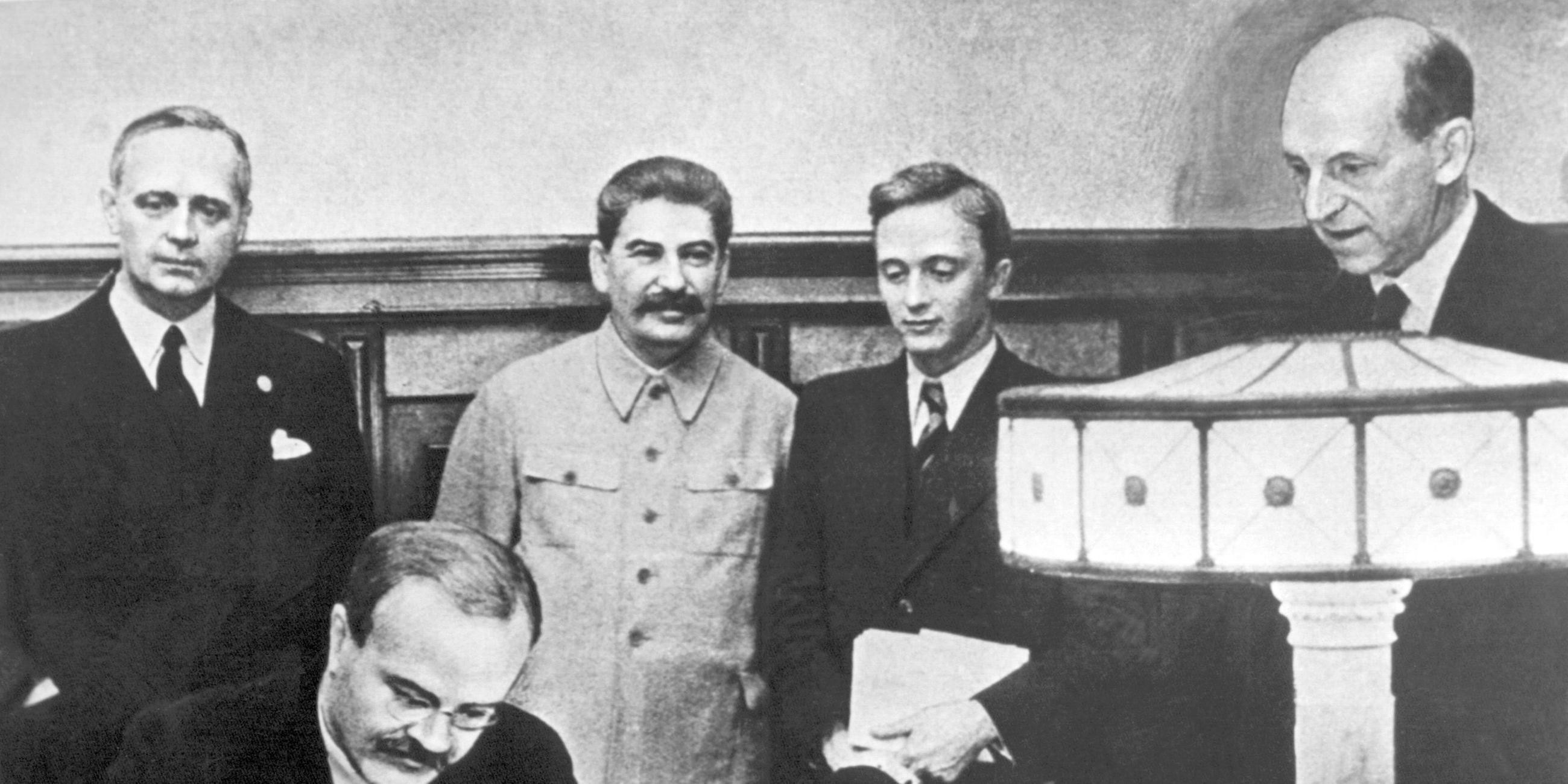 Am 23. august 1939 unterzeichneten der Außenminister des Deutschen Reiches, Joachim von Ribbentrop (l), und der sowjetische Außenminister Wjatscheslaw Molotow (vorn) in Moskau den deutsch-russischen Nichtangriffspakt. Hinten neben Ribbentrop Josef Stalin, ganz rechts Friedrich Gaus, daneben U. Pavlov.