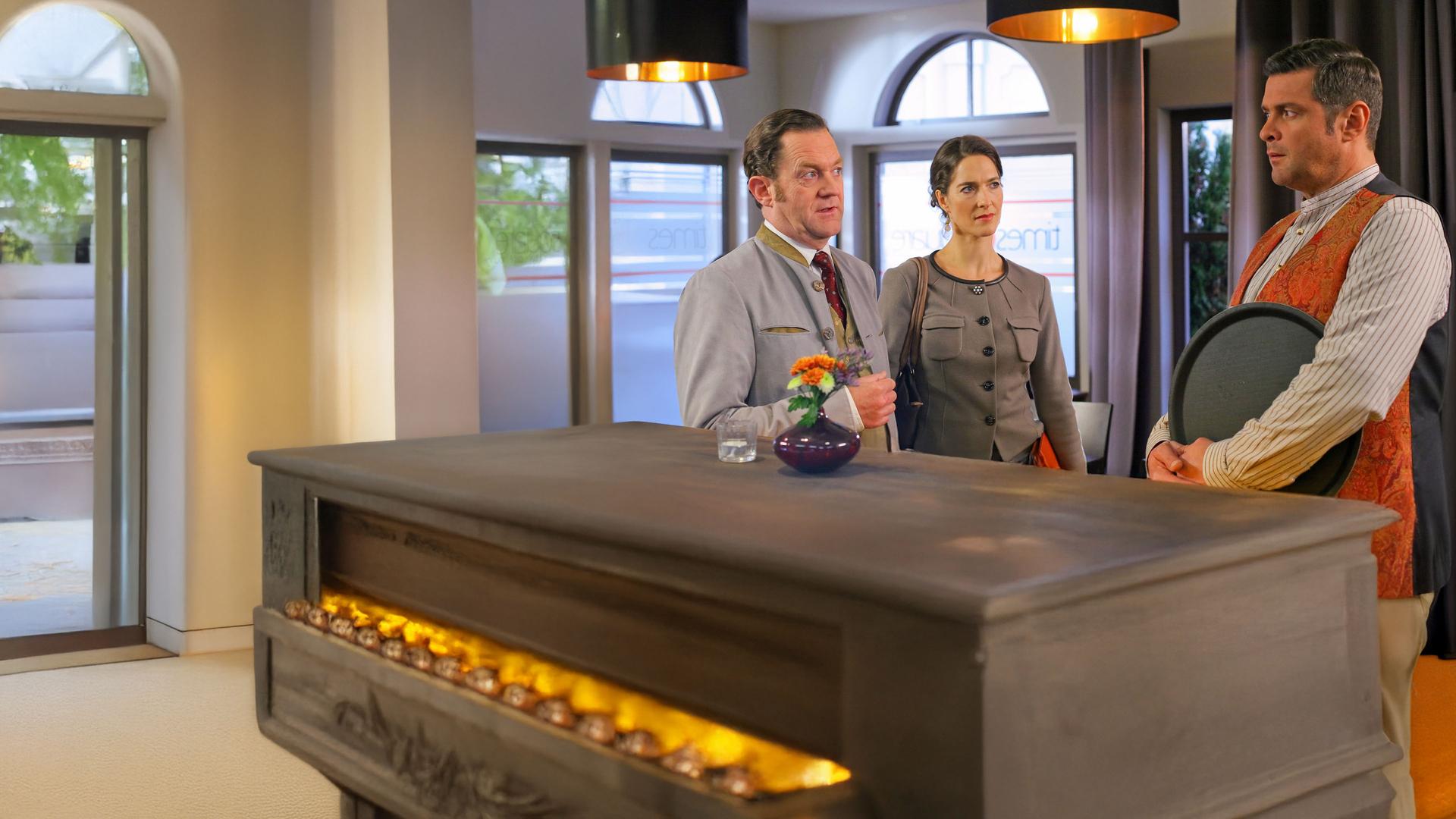 "Die Rosenheim-Cops - Der Letzte macht das Licht aus": Bürgermeister Schretzmayer (Jürgen Tonkel) und Claudia Henning (Margit Sartorius) unterhalten sich mit dem "times square"- Wirt Jo (Christian K. Schaeffer) in dessen Bistro.