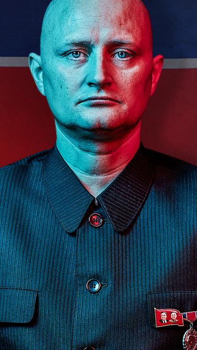 "Der Maulwurf - Undercover in Nordkorea: Freunde von Kim Jong Un ": Ein Mann in einer Uniform mit militärischen Abzeichen blickt ernst in die Kamera – im Hintergrund die nordkoreanische Flagge.