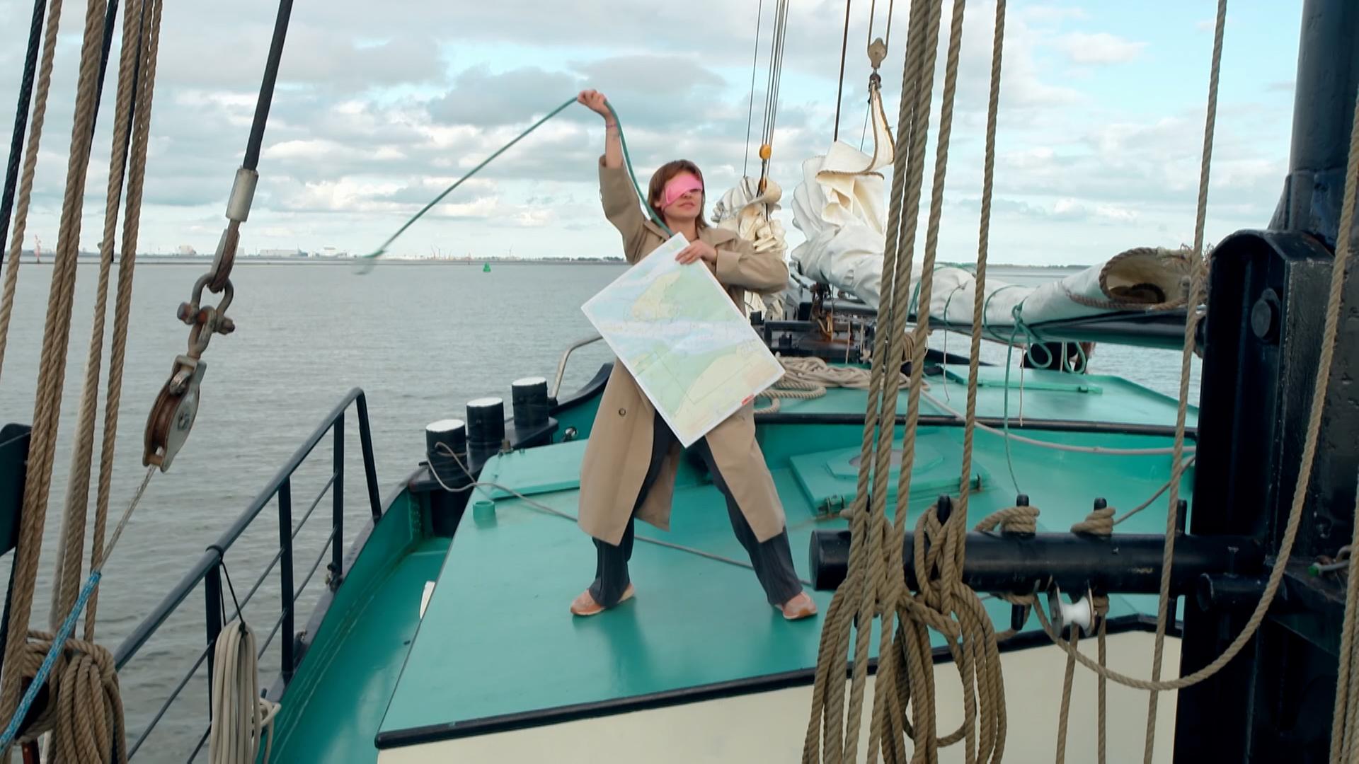 Angelina von der Allstars-WG steht auf einem Segelboot Sie hält eine Schatzkarte in der einen Hand und schwenkt ein Lasso in der anderen .