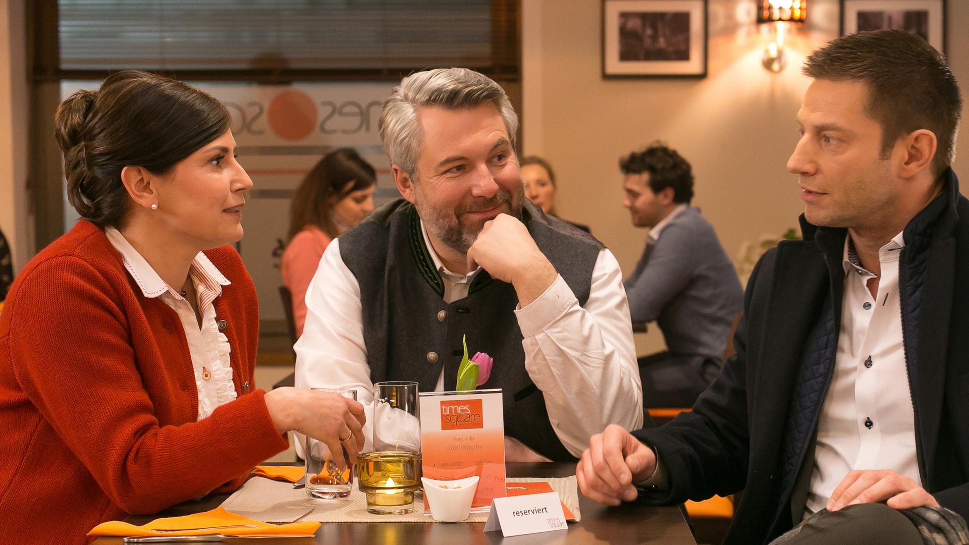 Hilde Stadler (Isabel Mergl), ihr Mann Anton (Dieter Fischer) und Sven Hansen (Igor Jeftic) sitzen um einen Tisch im Restaurant.