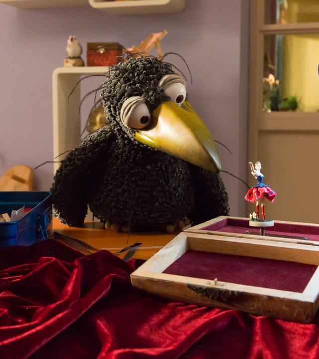 Rudi betrachtet neugierig die kleine Polka-Tänzerin, die vor ihm in einer Spieluhr steht.