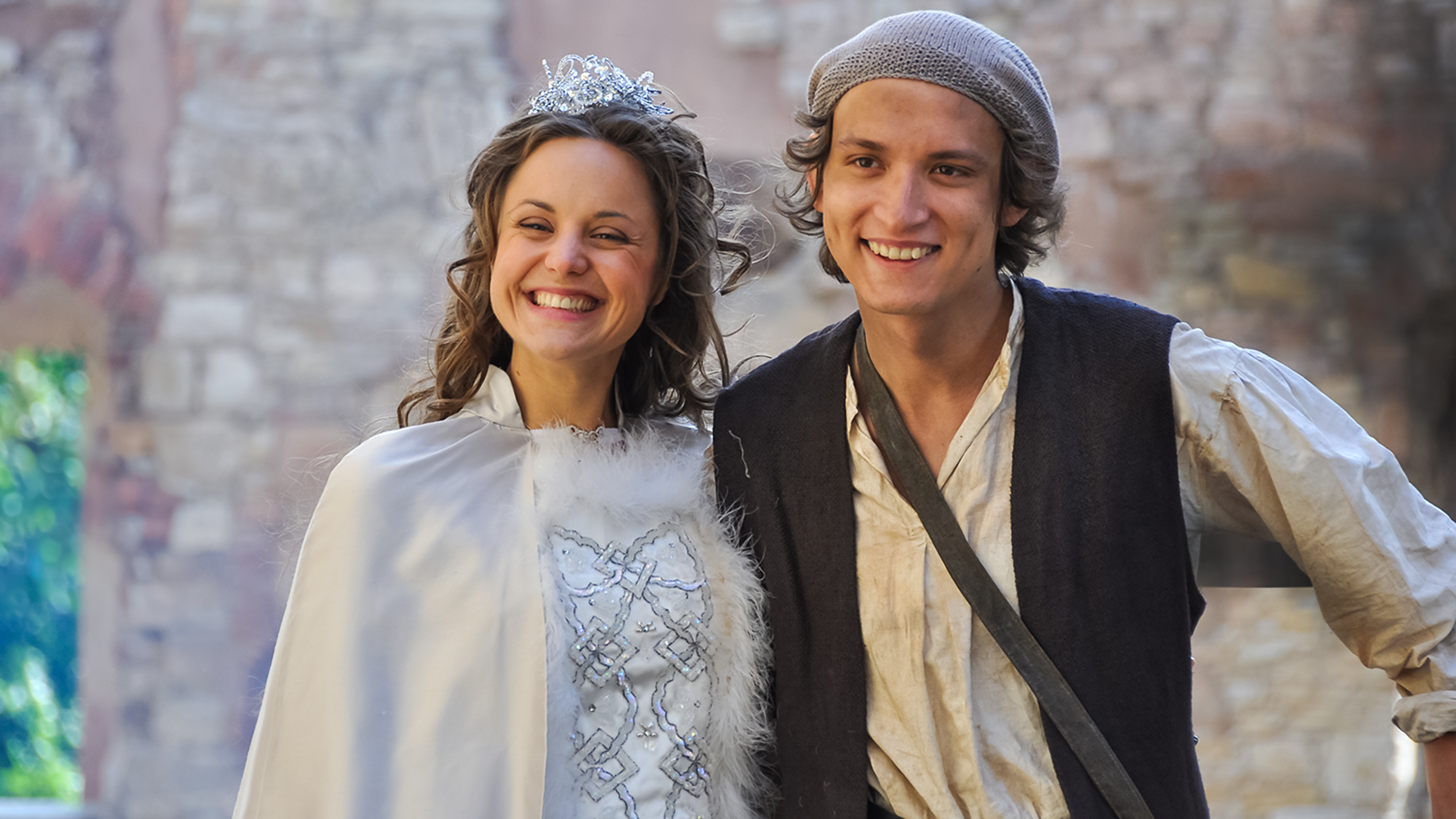 Hans (rechts) und die Königstochter (links neben ihm) strahlen vor Glück. Der Hintergrund ist hell verschwommen.