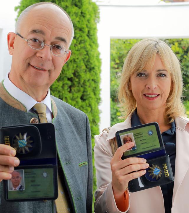 "Die Rosenheim-Cops - Der tote Bote": Polizeidirektor Gert Achtziger (Alexander Duda) und Verena Danner (Katharina Abt) stehen vor einer Haustür und zeigen ihre Ausweise vor.