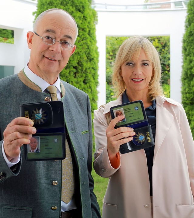 "Die Rosenheim-Cops - Der tote Bote": Polizeidirektor Gert Achtziger (Alexander Duda) und Verena Danner (Katharina Abt) stehen vor einer Haustür und zeigen ihre Ausweise vor.