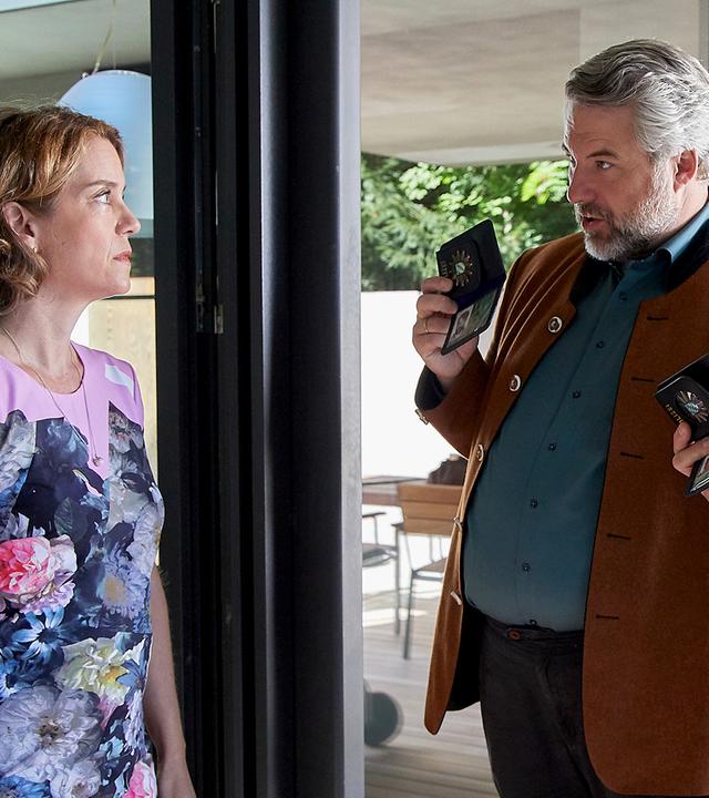 Saskia Beck (Louisa Stroux) steht in im Rahmen ihrer Terrassentür und sieht die Kommissare Stadler (Dieter Fischer) und Hansen (Igor Jeftić) an, die mit gezückter Polizeimarke vor ihr stehen.