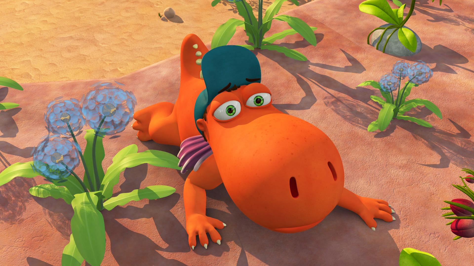 Kokosnuss liegt flach auf der Erde zwischen den Blumen.