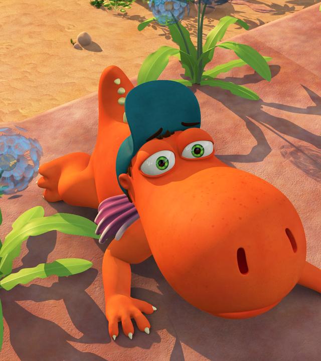 Kokosnuss liegt flach auf der Erde zwischen den Blumen.