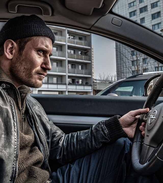 "Der Überfall - Donnerstag: Der Plan": Frank Worms (Sebastian Zimmler) sitzt hinter dem Steuer seines Wagens und beobachtet die Umgebung draußen ganz genau.