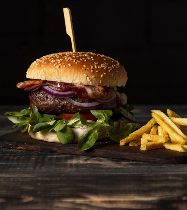 Ein Hamburger und eine Portion Pommes frites auf einem Tisch.