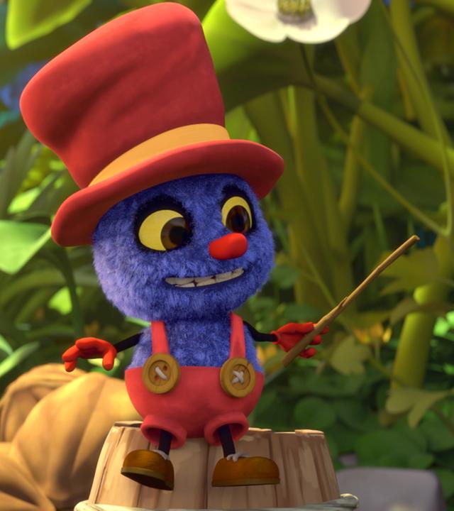 Klaus sitzt auf einem Baumstamm und hält einen Stock in der Hand. Er sieht glücklich aus.